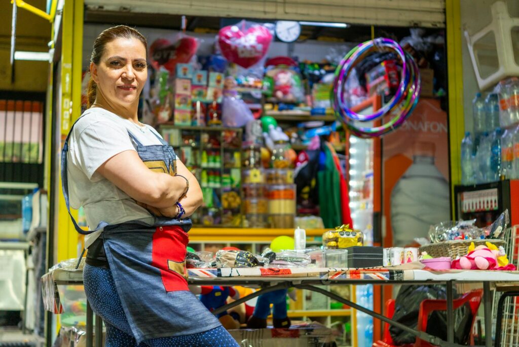 Latin American woman proudly standing at her vibrant Ciudad de México market stall.